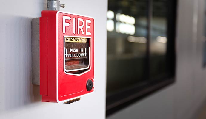 Activated fire alarm pull station on wall