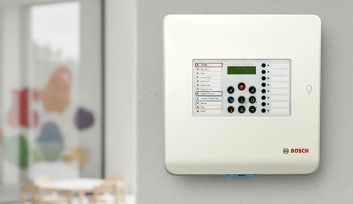 Bosch white conventional fire alarm control panel mounted on a wall