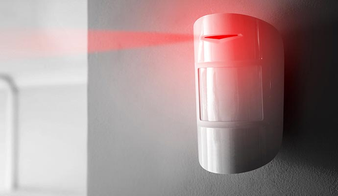 Wall-mounted infrared motion sensor detector emitting security beam