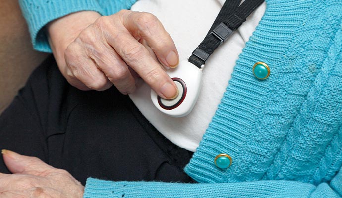 Elderly person pressing medical alert button