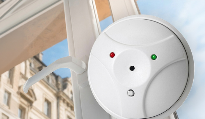 Acoustic glass break detector sensor mounted on window glass frame