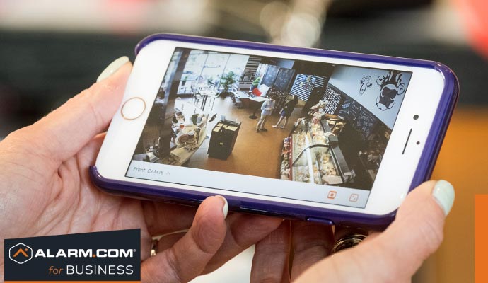Person monitoring video footage on smartphone