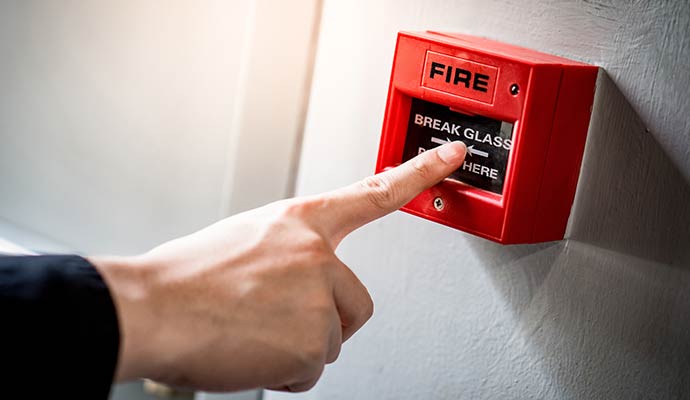 Person using fire alarm button