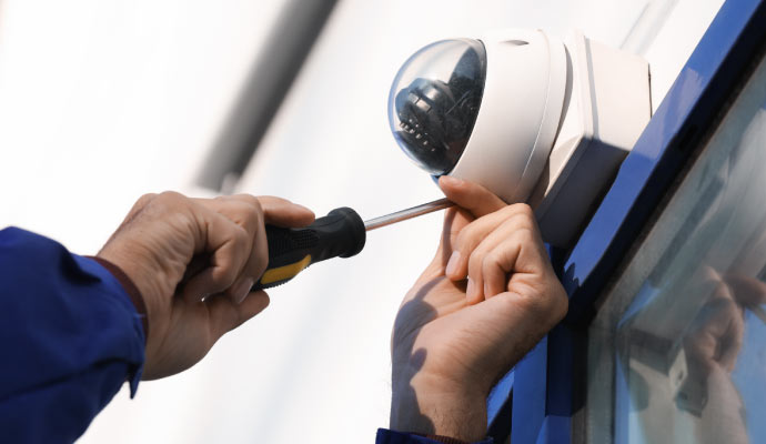 Person installing a camera on the wall.