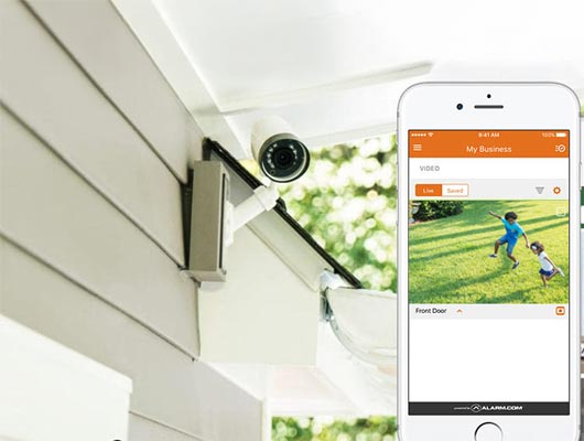 Installed security camera displaying live footage on smartphone