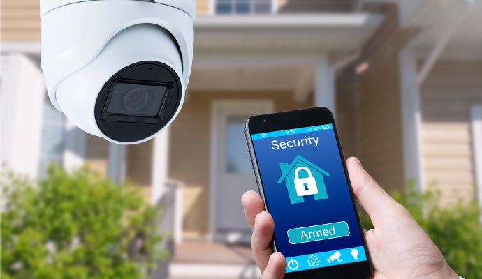A panoramic home security camera and a smartphone displaying home security app A panoramic home security camera and a smartphone displaying home security app