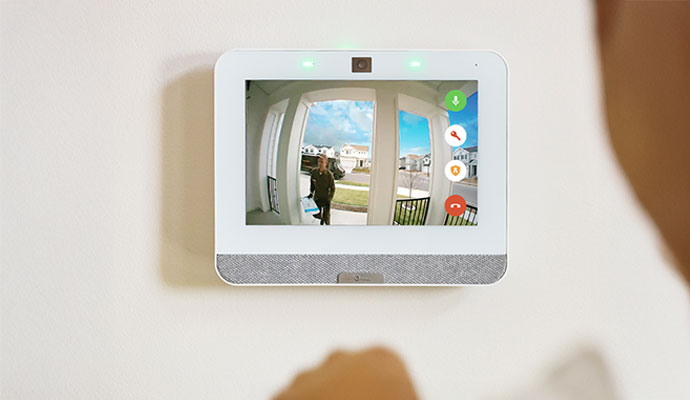 A wall-mounted smart video doorbell displaying a live video feed