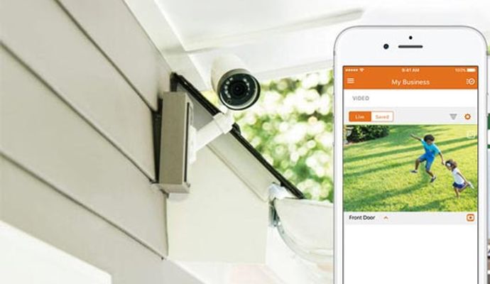 Installed security camera displaying live footage on smartphone