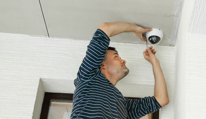 Technician installing dome security camera Technician installing dome security camera