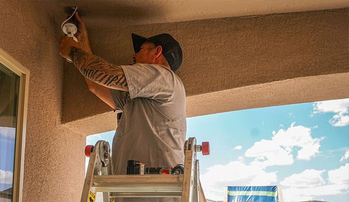 Security technician installing outdoor security camera